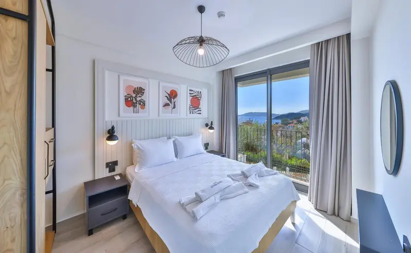 Une chambre lumineuse avec un grand lit et une vue sur la mer.