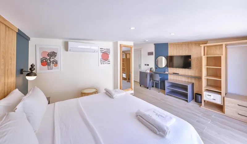 Une chambre lumineuse avec un grand lit et un espace bureau.