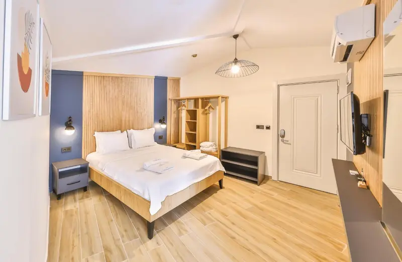 Une chambre lumineuse avec un lit double et un espace de rangement.
