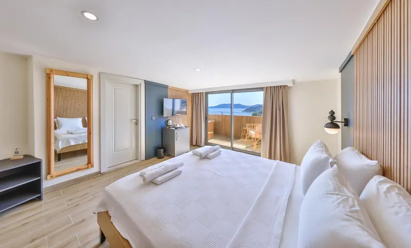 Chambre lumineuse avec un grand lit et un miroir en pied.