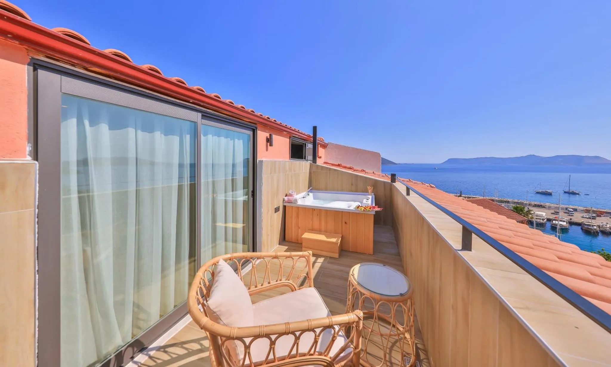 Terrasse avec jacuzzi et mobilier de jardin offrant une vue sur la mer.