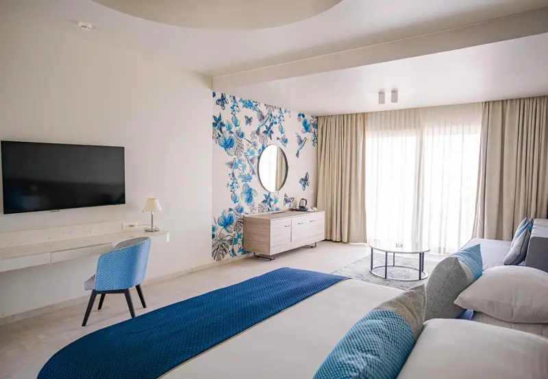 Une chambre lumineuse avec un grand lit et un coin salon.