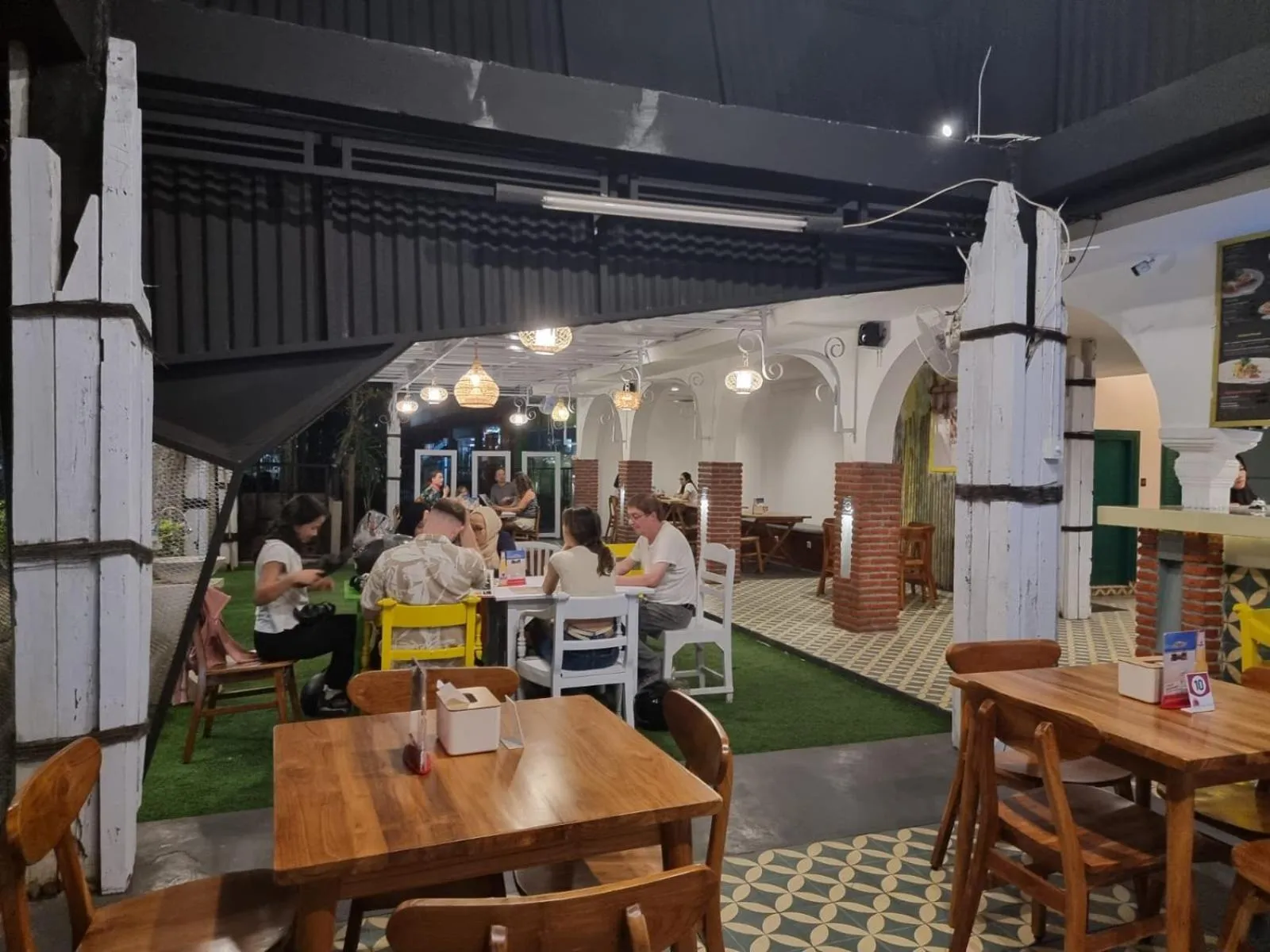 Une salle à manger lumineuse avec des tables en bois et des chaises.