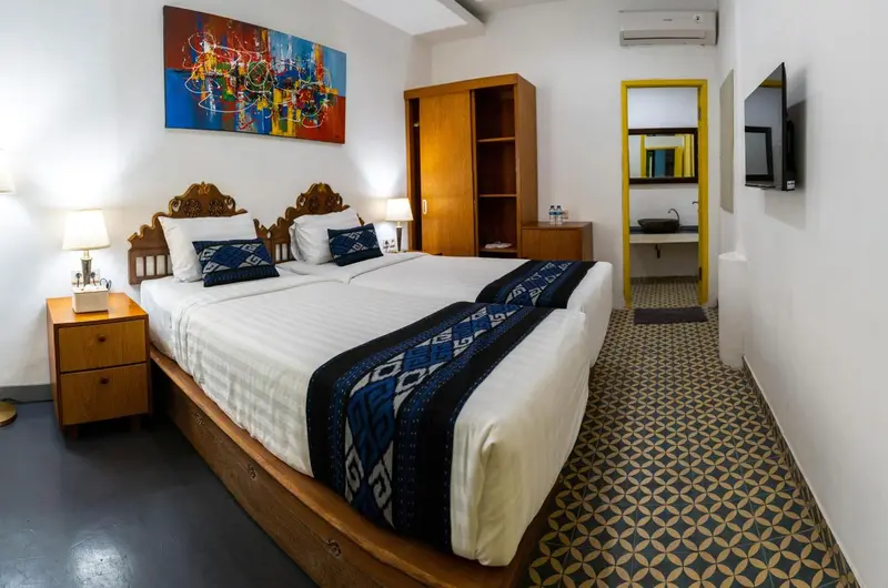 Une chambre lumineuse avec un grand lit et une décoration colorée.
