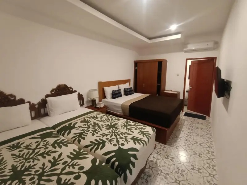 Une chambre lumineuse avec un grand lit et un meuble en bois.