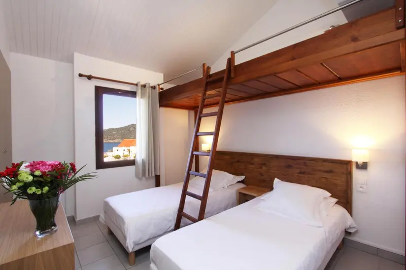 Une chambre avec lits superposés et vue sur la mer.
