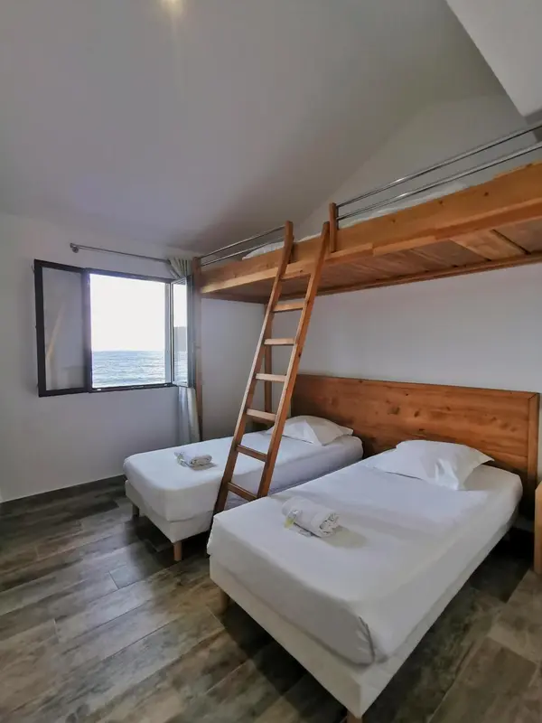 Chambre avec lits superposés et vue sur la mer.