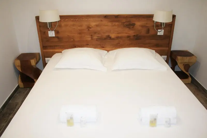 Un lit double blanc avec des oreillers moelleux dans une chambre lumineuse.