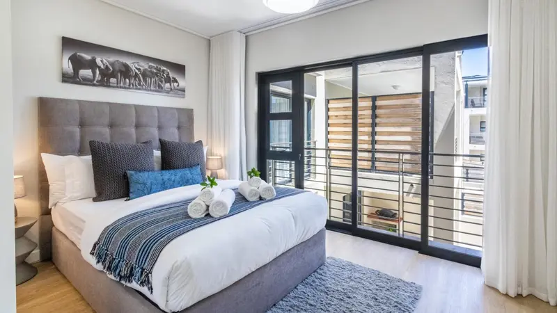 Une chambre lumineuse avec un grand lit et un accès à une terrasse.
