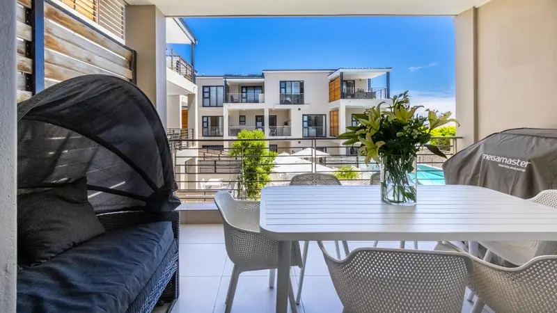 Terrasse aménagée avec salon et table à manger donnant sur une cour intérieure.