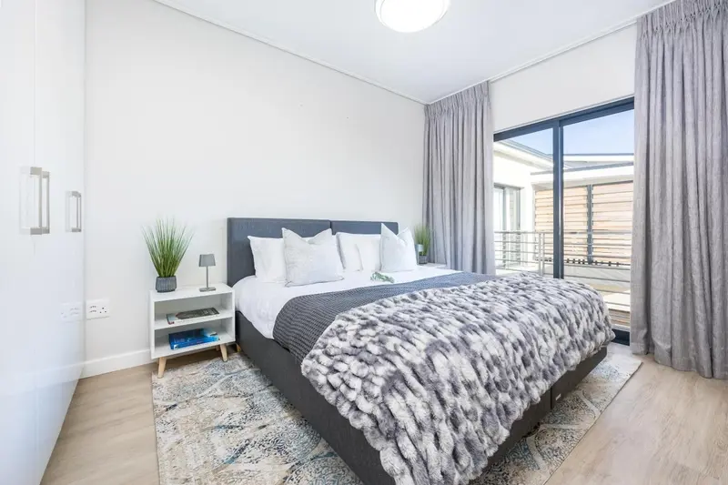 Une chambre moderne avec un grand lit et un accès à une terrasse.