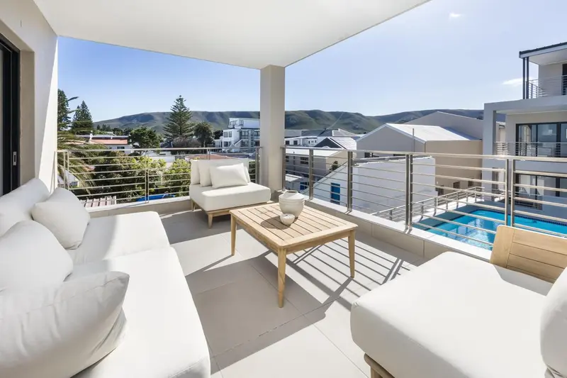 Terrasse aménagée avec canapés blancs et vue sur la mer et les environs.