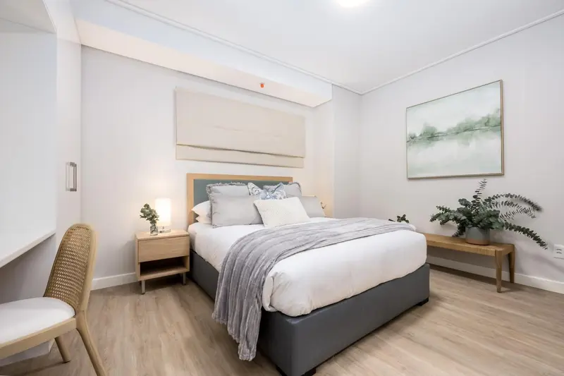 Une chambre lumineuse avec un grand lit et une décoration sobre.