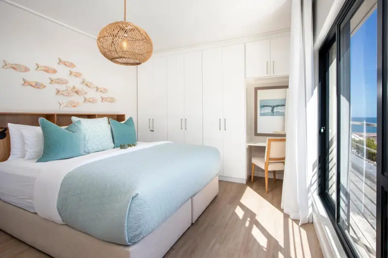 Une chambre lumineuse avec un grand lit et une vue sur la mer.