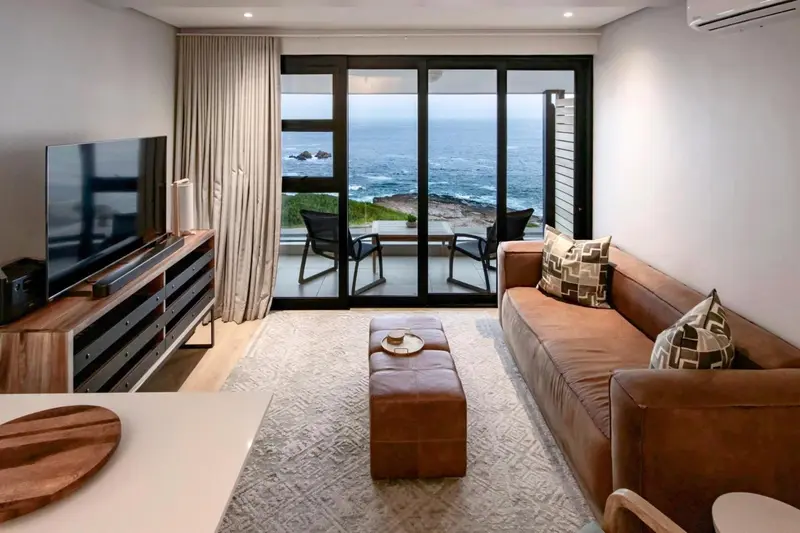 Un salon moderne s'ouvre sur une terrasse avec vue sur la mer.