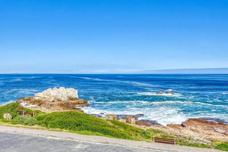 Vue panoramique sur une côte rocheuse et l'océan bleu.