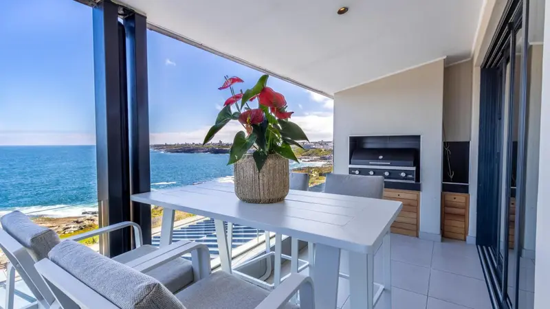 Terrasse avec mobilier d'extérieur et vue sur la mer.