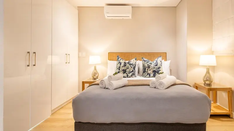 Une chambre lumineuse avec un grand lit et des meubles clairs.