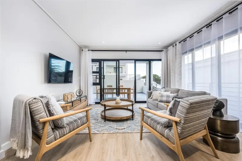 Un salon clair et moderne avec canapés et fauteuils confortables.