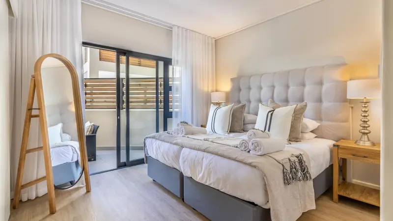 Une chambre lumineuse avec un grand lit et un accès à une terrasse.