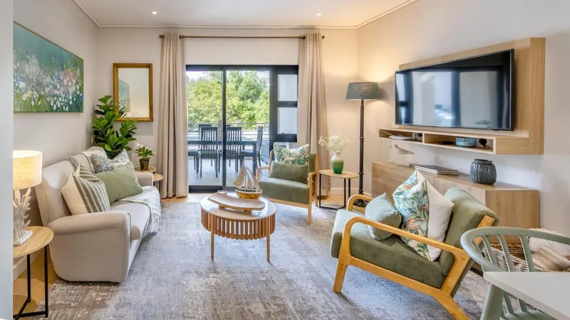 Un salon lumineux avec canapés, fauteuils et une vue sur une terrasse.