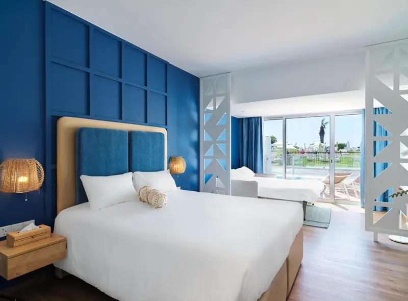 Une chambre lumineuse avec un grand lit et un accès à une terrasse.