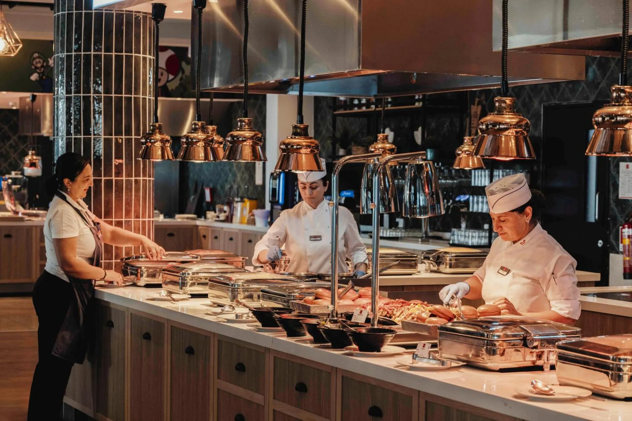 Un buffet propose une variété de plats préparés par des employés en uniforme.