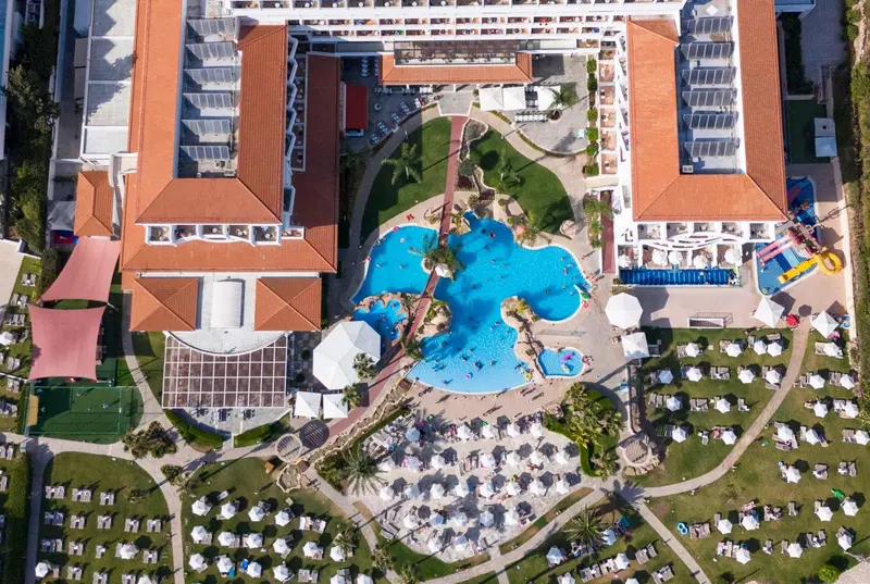 Vue aérienne d'un complexe hôtelier avec piscine et espaces verts.
