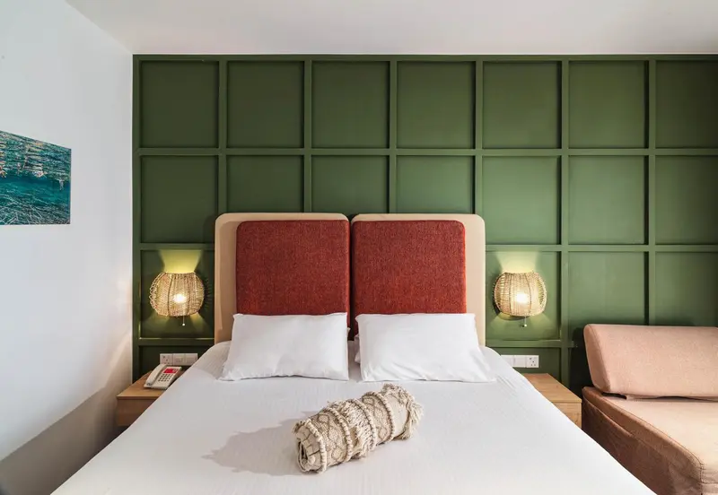 Une chambre avec un grand lit et une tête de lit rouge.