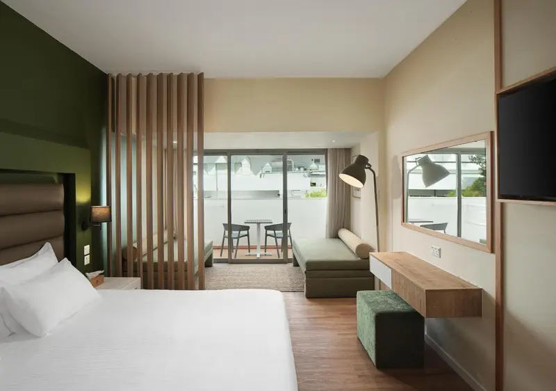 Une chambre lumineuse avec un grand lit et un espace détente.