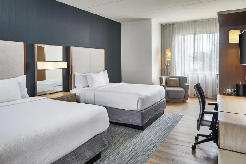 Une chambre d'hôtel avec deux lits et un espace de travail.