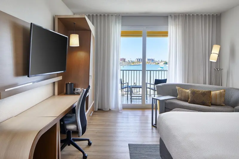 Une chambre lumineuse avec un coin salon et un balcon donnant sur la mer.