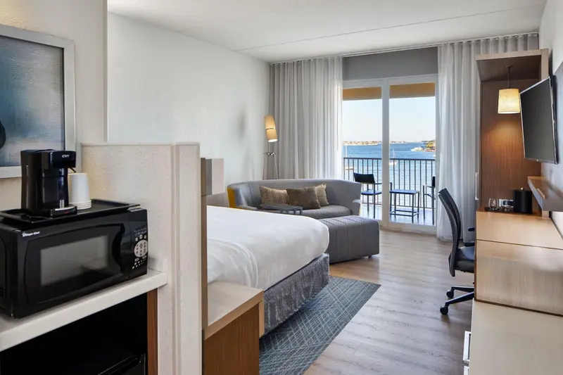 Une chambre lumineuse avec un coin salon et une vue sur la mer.