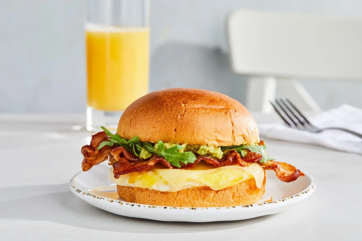 Un hamburger et un jus d'orange sont servis sur une table.