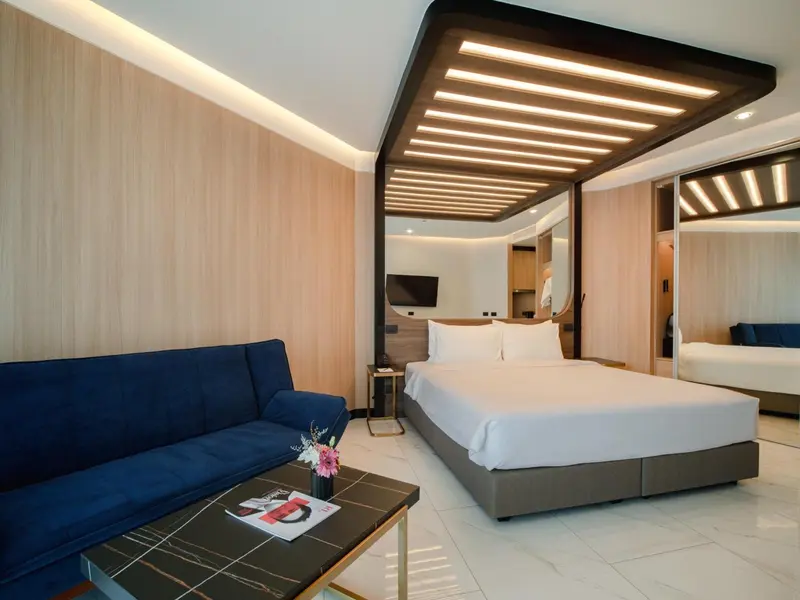 Une chambre moderne avec un canapé bleu et un grand lit.
