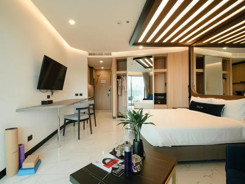 Une chambre moderne avec un lit, un bureau et un espace détente.