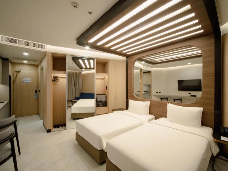 Chambre moderne avec deux lits simples et un espace détente.