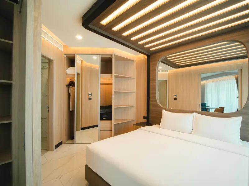 Une chambre lumineuse avec un grand lit et un placard intégré.