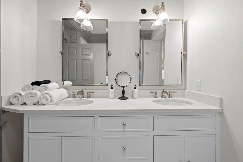 Vanité double avec des serviettes pliées et des miroirs au-dessus.