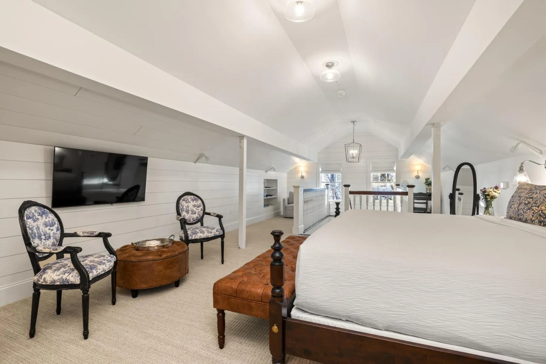 Espace de détente lumineux avec télévision et mobilier ancien.