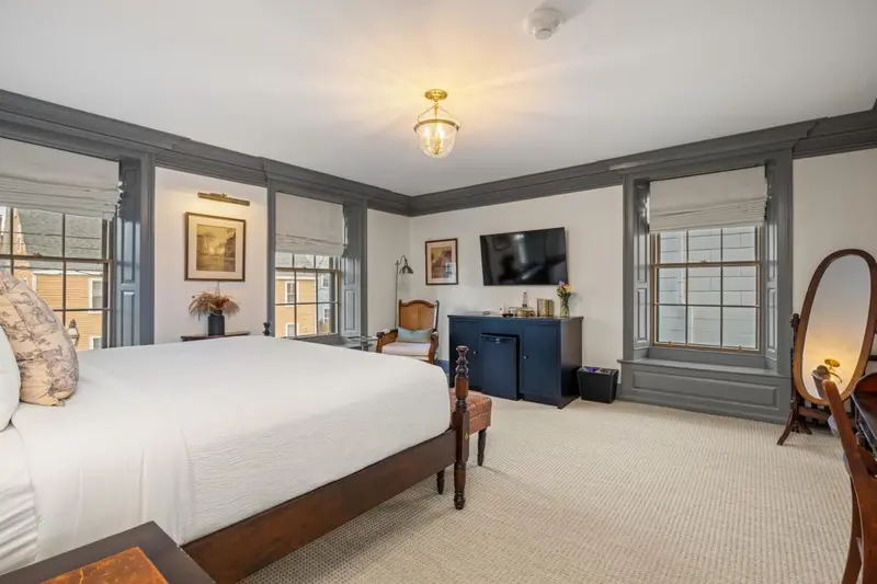 Une chambre lumineuse avec un grand lit et un mobilier en bois.