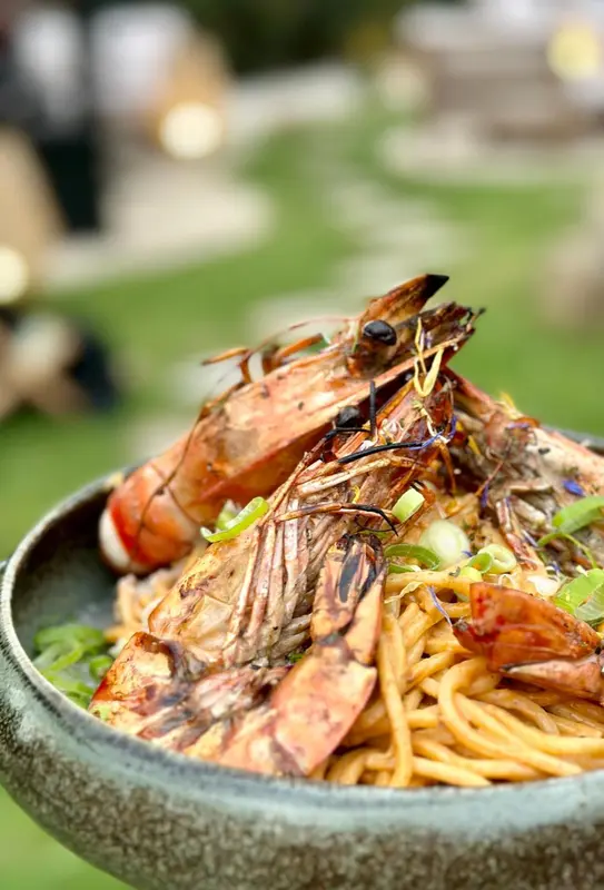 Assiette de nouilles aux crevettes grillées et aux légumes.