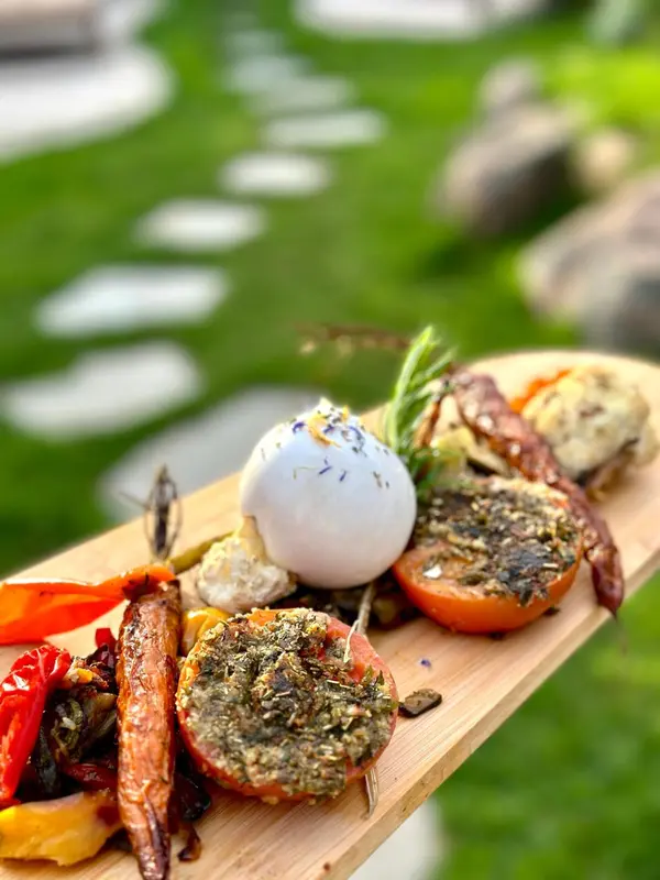 Assiette de légumes grillés et d'œuf sur une planche en bois.