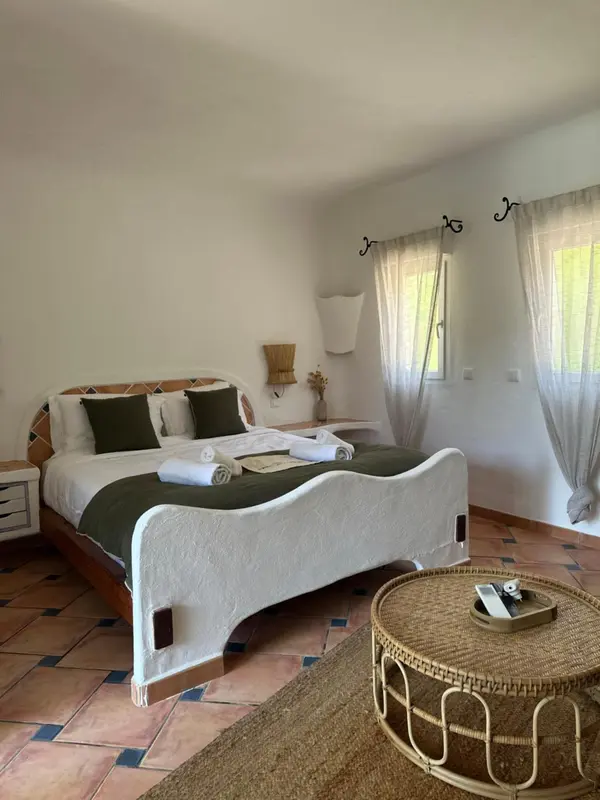 Une chambre lumineuse avec un lit à baldaquin et une fenêtre ouverte.