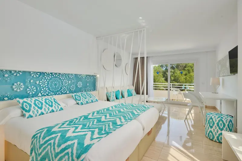 Une chambre lumineuse avec un grand lit et un accès à une terrasse.