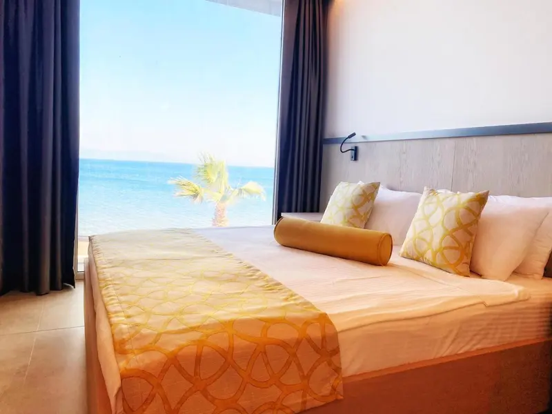 Une chambre lumineuse avec un grand lit donnant sur la mer.
