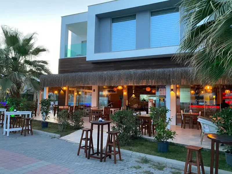 Terrasse de restaurant avec tables et chaises en extérieur.
