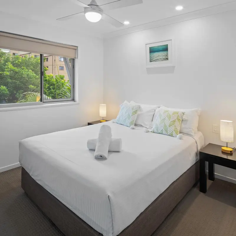 Une chambre lumineuse avec un grand lit et une décoration sobre.