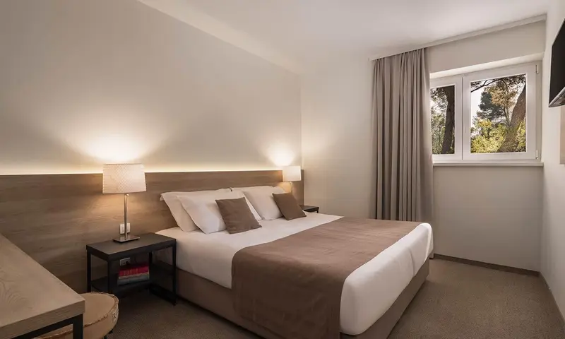 Une chambre lumineuse avec un grand lit et des lampes de chevet.