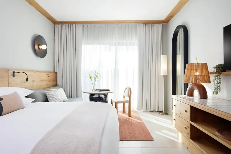 Une chambre lumineuse avec un grand lit et une décoration moderne.
